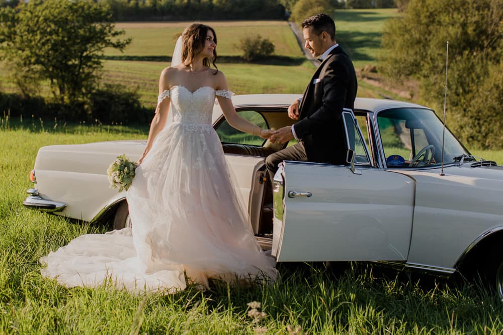 Mercedes Oldtimer mit Braut und Bräutigam – stilvolles Hochzeitsportrait vor dem Fahrzeug