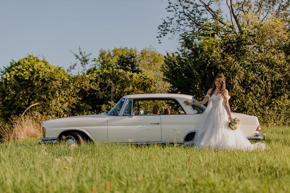 Mercedes Oldtimer mit Braut – stilvolles Hochzeitsportrait vor dem Fahrzeug