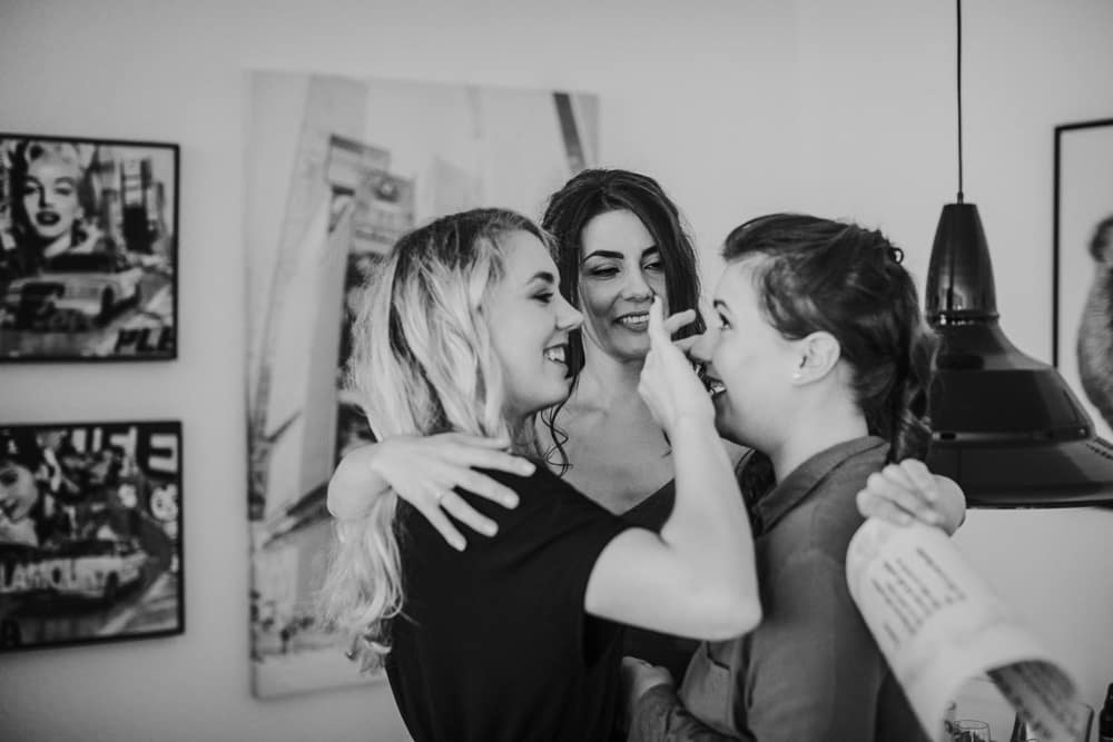 die Trauung Brautjungfern helfen beim Anziehen des Hochzeitskleides – emotionale Unterstützung am Morgen