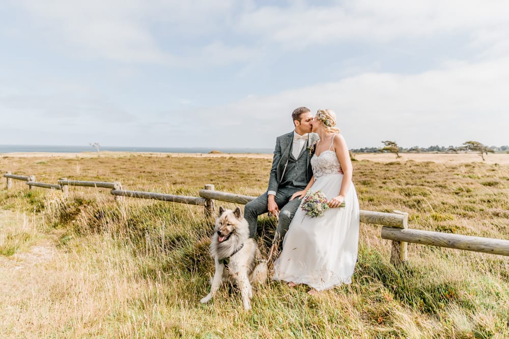 Braut und Bräutigam beim Brautpaarfotoshooting in den Dünen auf Sylt. Hochzeitsfotografin für Hochzeitsreportage auf Sylt buchen.