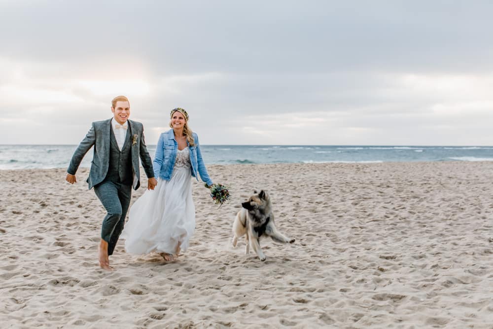 Sonnenuntergang am Meer auf Sylt beim Brautpaarfotoshooting und dem Hund, Hochzeitsfotografin für Hochzeitsreportage auf Sylt buchen